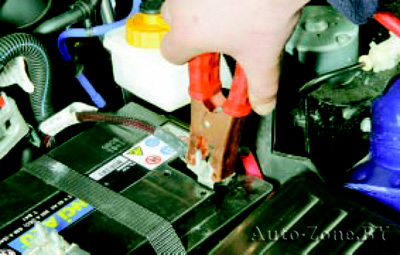 Присоедините зажим соединительного кабеля с рукоятками красного цвета к клемме «плюс» разряженной батареи