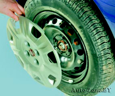 Поднимите домкратом автомобиль так, чтобы колесо оторвалось от дороги, после чего полностью выверните болты, снимите декоративный колпак