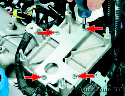 Выверните четыре винта крепления держателя жгутов проводов к кронштейну блока управления двигателем