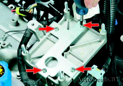 Выверните четыре винта крепления держателя жгутов проводов к кронштейну блока управления двигателем