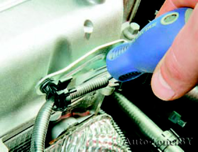 Разожмите держатель жгута проводов управляющего датчика концентрации кислорода