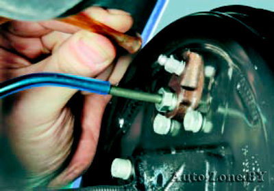 Наденьте шланг на клапан для выпуска воздуха рабочего цилиндра тормозного механизма правого заднего колеса и погрузите второй конец шланга в чистый прозрачный сосуд