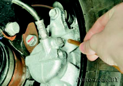 Наденьте шланг на клапан для выпуска воздуха рабочего цилиндра тормозного механизма левого переднего колеса и погрузите второй конец шланга в чистый прозрачный сосуд