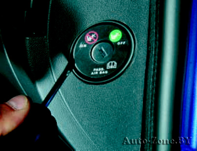Отожмите тонкой отверткой фиксатор выключателя подушки безопасности переднего пассажира