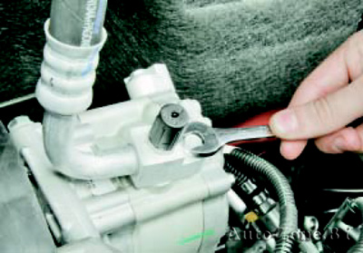 Выверните болт крепления фланца трубопровода низкого давления к компрессору и отсоедините фланец трубопровода от компрессора
